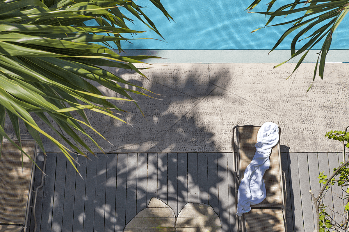 Overhead view of pool and patio lounger with towel.