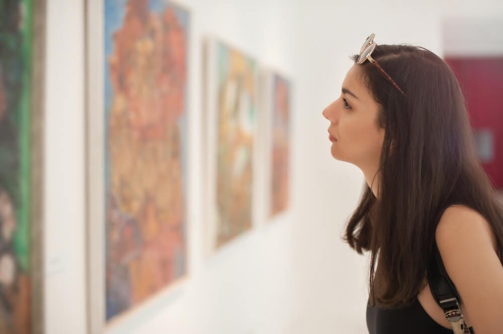 A photo of a woman looking at work in one of the various Key West art galleries.