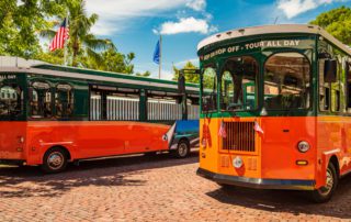 Two trolleys that are part of the trolley tour service in Key West.