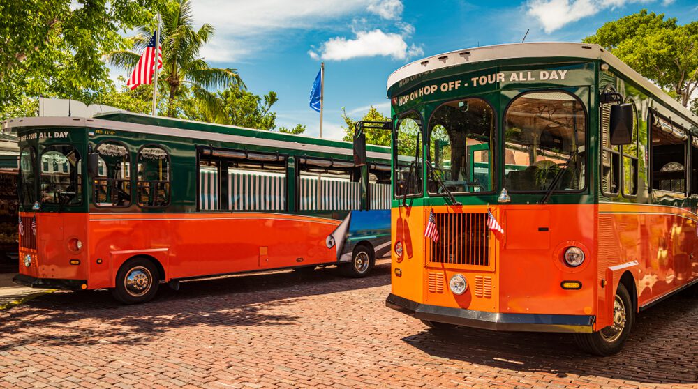 Two trolleys that are part of the trolley tour service in Key West.